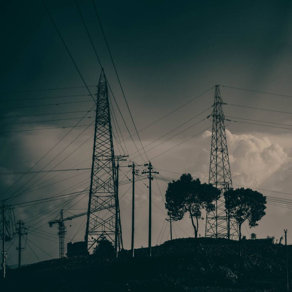 Scenic view of transmission towers against a cloudy sky